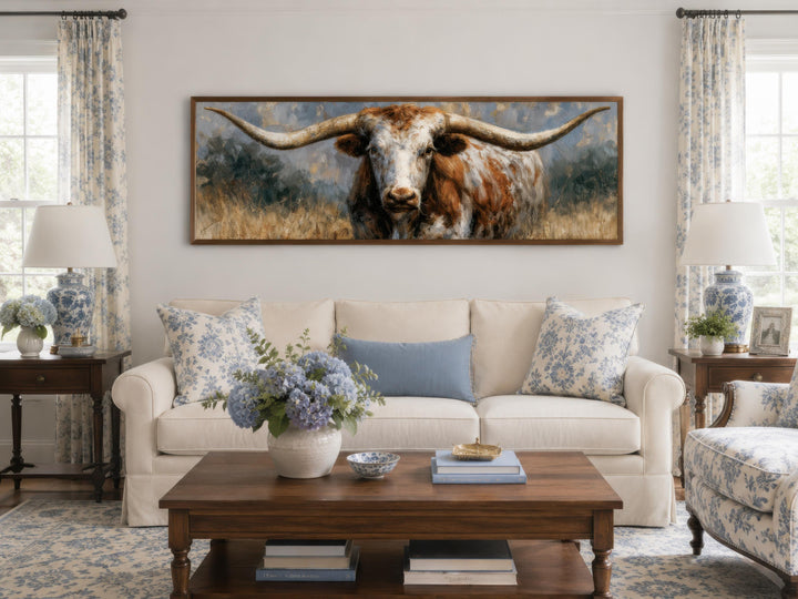 Texas Longhorn wall art canvas print in a wide horizontal frame above a white sofa.