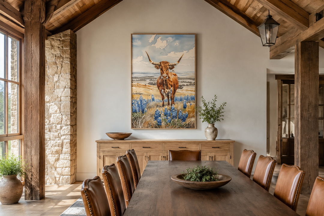 Vertical framed canvas wall art of a Texas longhorn cow in a bluebonnet field in a rustic dining room