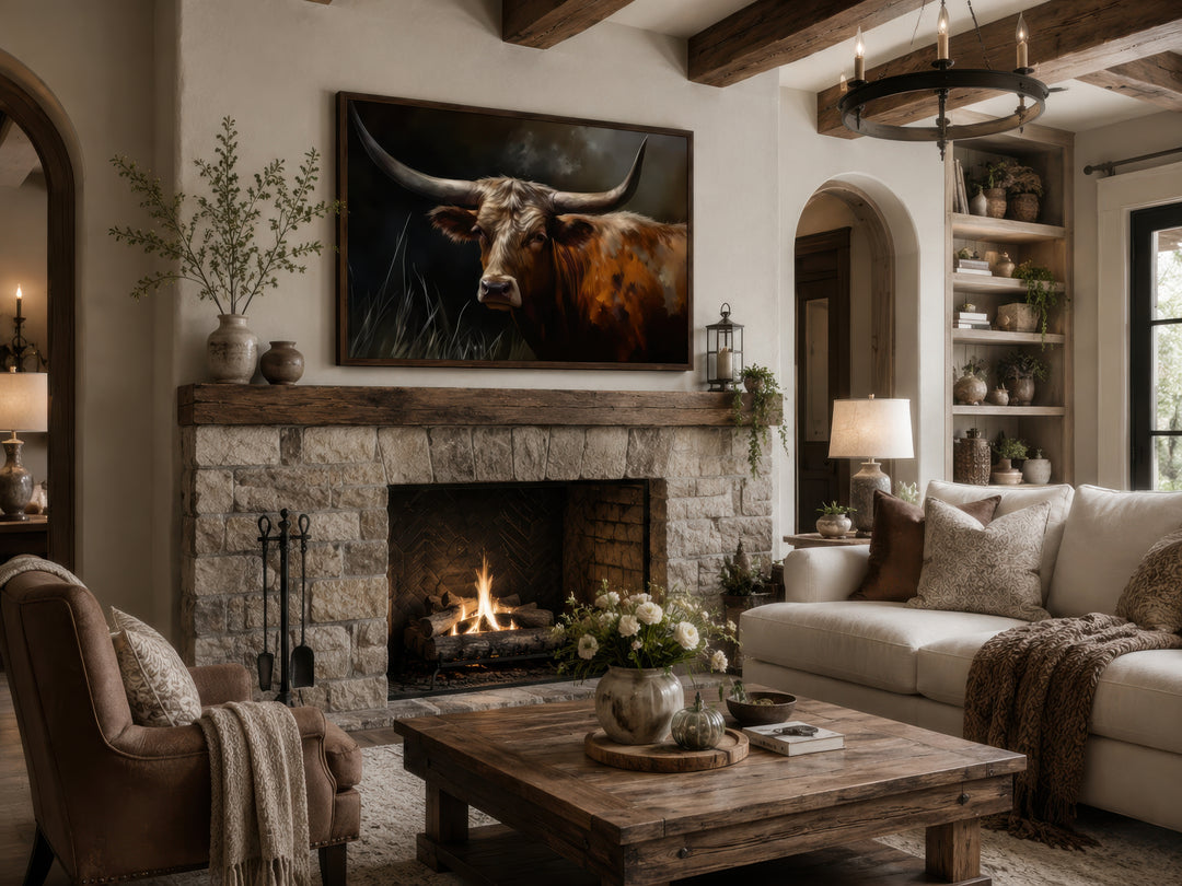 Brown Texas Longhorn cow framed canvas wall art hanging above a stone fireplace in a rustic room.