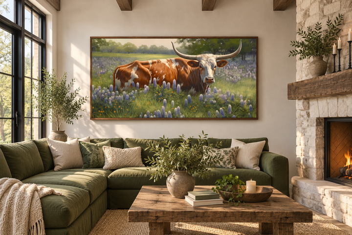 Texas Longhorn cow in a field of bluebonnets framed canvas wall art above a green sectional sofa.