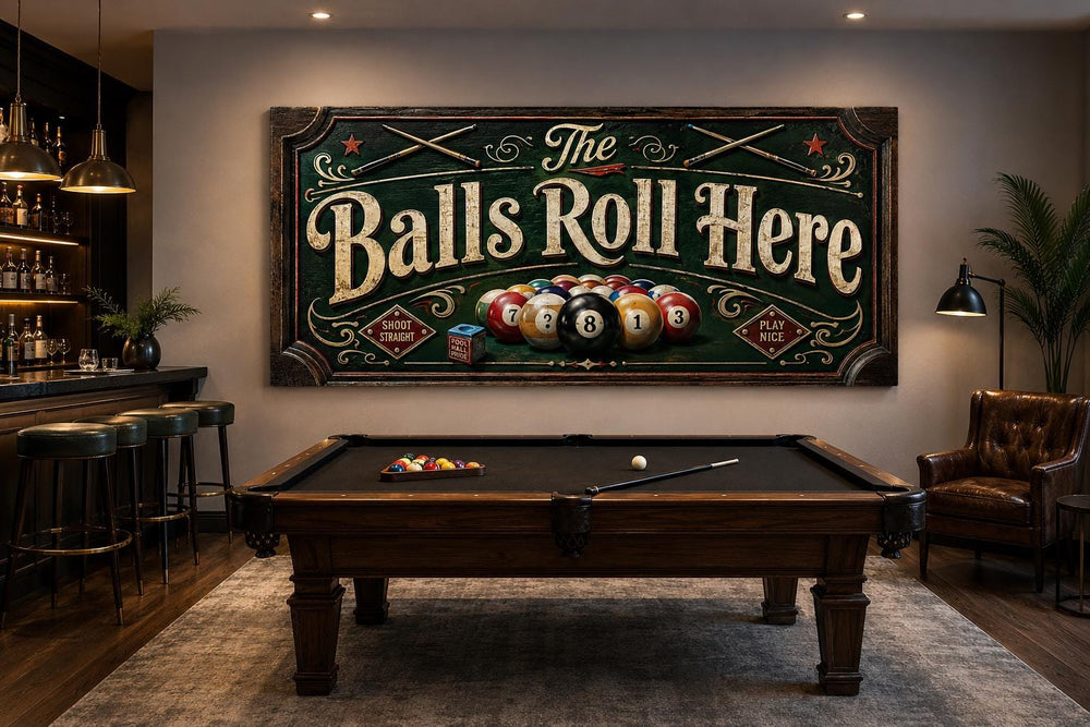 Vintage-style 'The Balls Roll Here' billiards sign canvas hanging above a pool table in a game room.