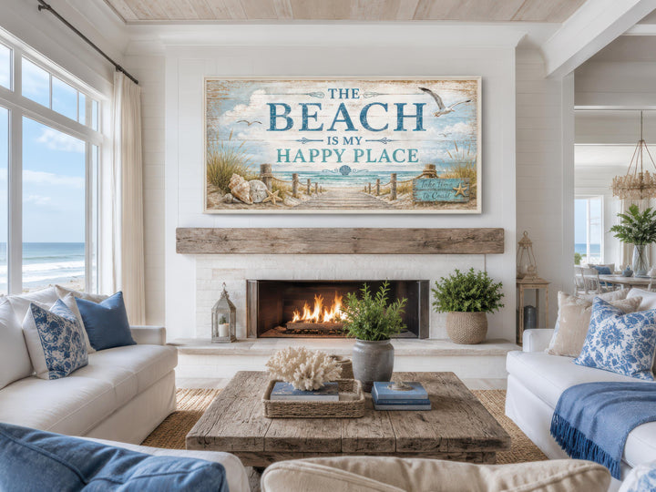 The Beach Is My Happy Place Sign canvas wall art hanging above a fireplace in a coastal living room.