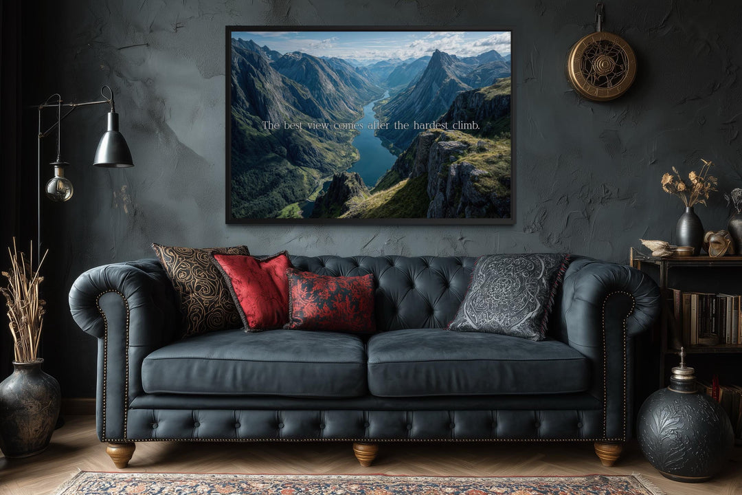 Wall art with the quote "The best view comes after the hardest climb" over a mountain landscape.