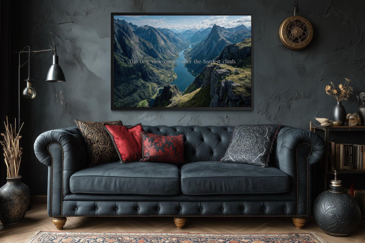 Wall art with the quote "The best view comes after the hardest climb" over a mountain landscape.