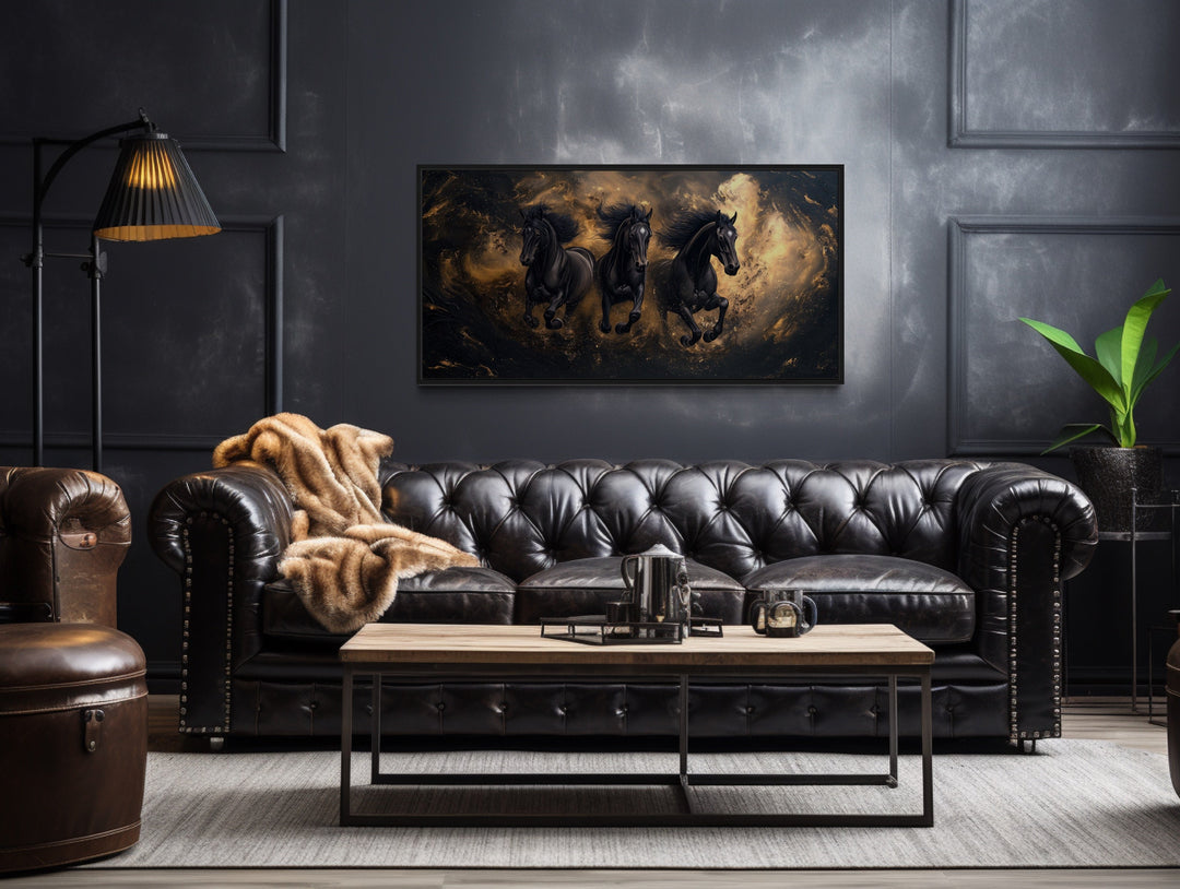 Three Running Stallions On Black Gold Background Framed Canvas Wall Art in a living room with a leather couch