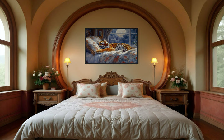 Framed canvas wall art of a tiger sleeping in a bed by a moonlit window, hung above a bedroom bed.
