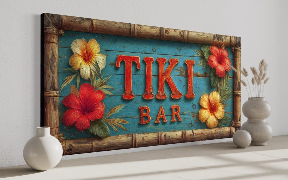 Tiki Bar wall art canvas with red carved-style lettering, hibiscus flowers, and a bamboo frame.