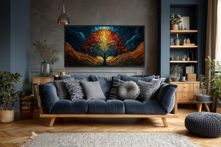 A colorful canvas print of a glowing Tree of Life hangs above a blue sofa in a modern living room.