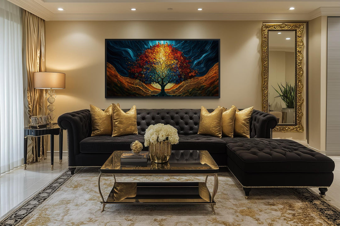 A colorful canvas print of a glowing Tree of Life hangs above a black sofa in a modern living room.