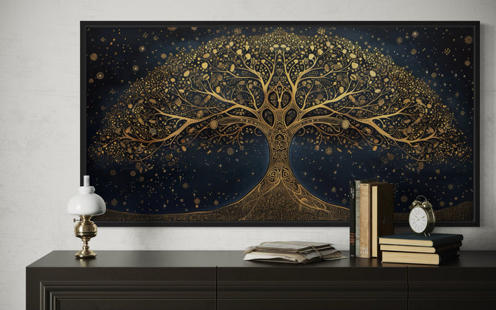 Framed canvas wall art of a golden Tree of Life on a navy blue background above a dark dresser.