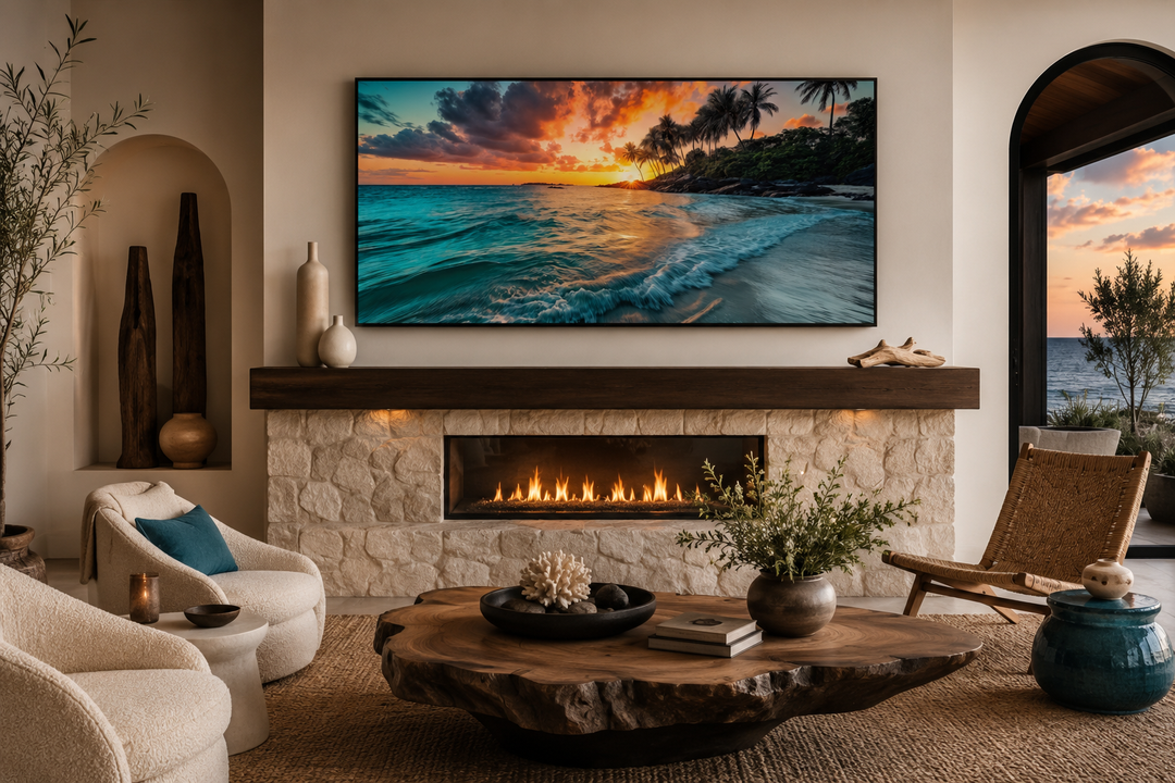 Framed canvas wall art of a tropical beach sunset with palm trees above a stone fireplace.