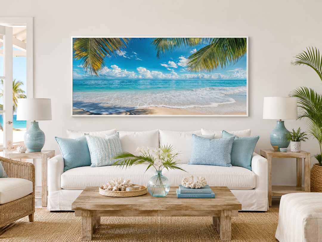 Tropical beach framed canvas wall art with palm trees and turquoise ocean over a white sofa.