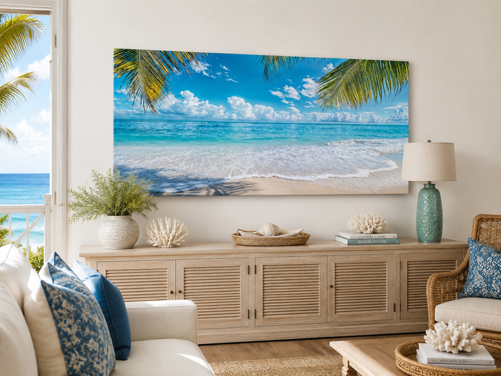 Tropical beach with palm trees framed canvas wall art above a wooden sideboard in a coastal room.