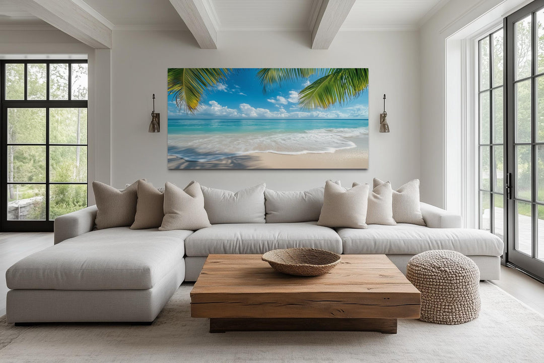 Tropical beach with palm trees framed canvas wall art hanging above a modern sectional sofa.