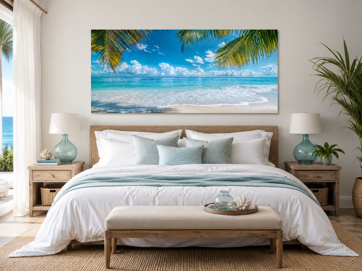 Tropical beach with palm trees framed canvas wall art hanging above a bed in a coastal bedroom.