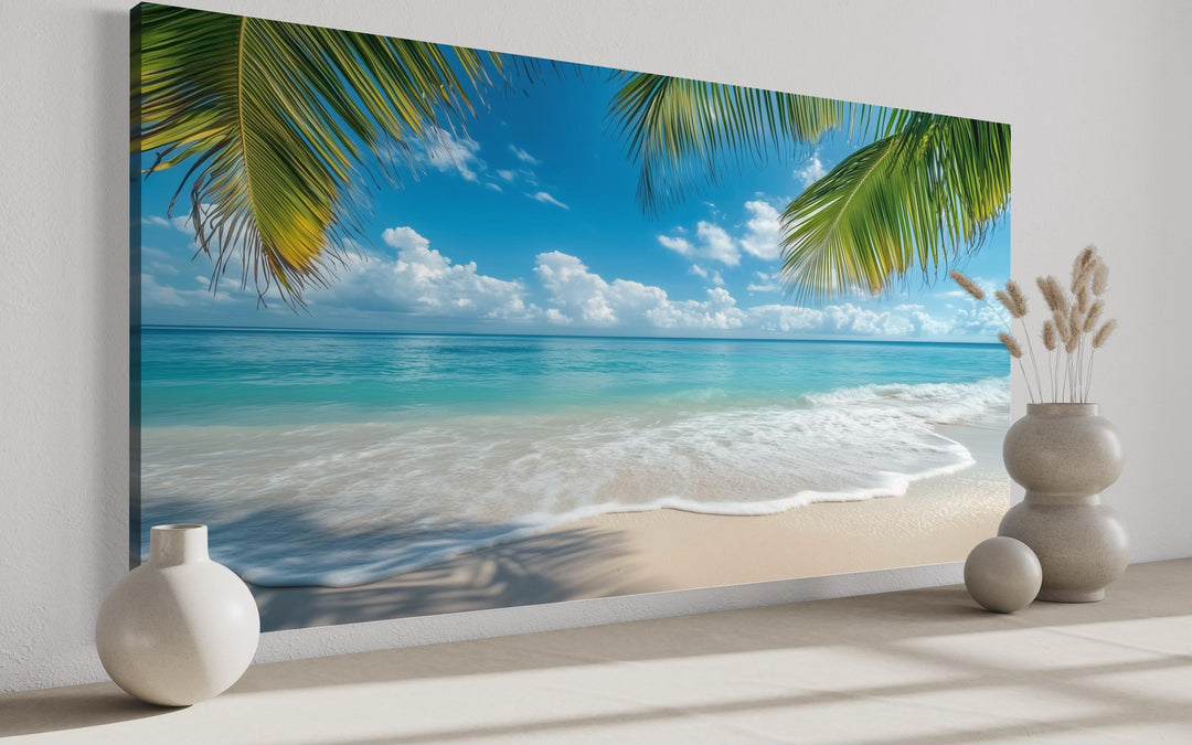 Tropical beach framed canvas wall art featuring turquoise water, white sand, and palm tree fronds.