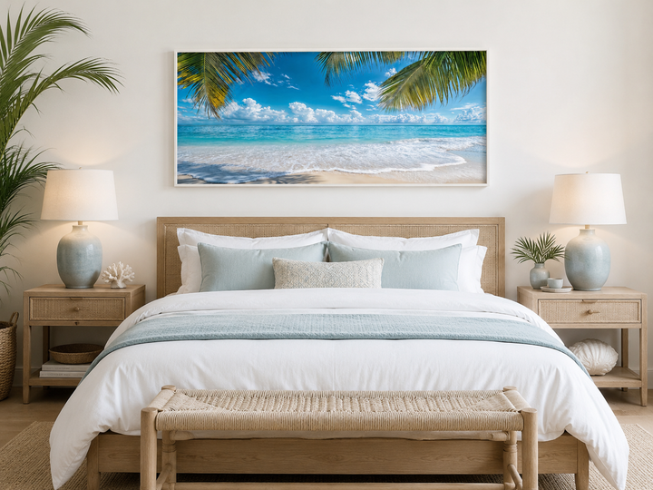 Tropical beach with palm trees framed canvas wall art hanging above a bed in a coastal bedroom.