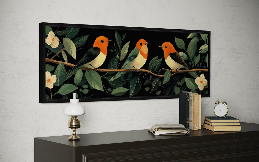 Panoramic canvas print of three colorful tropical birds perched on a branch among lush green leaves.