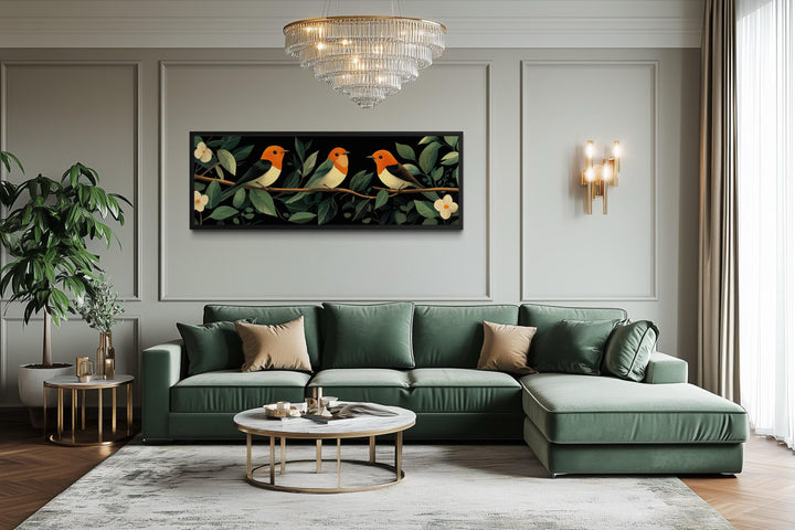 Tropical birds canvas print above a green sofa in a modern living room with a crystal chandelier.