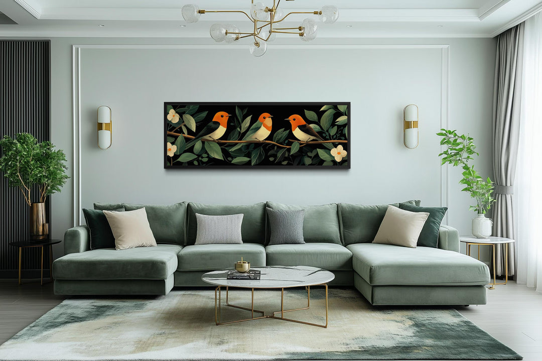 A horizontal canvas print of three colorful tropical birds perched on a branch in a modern room.