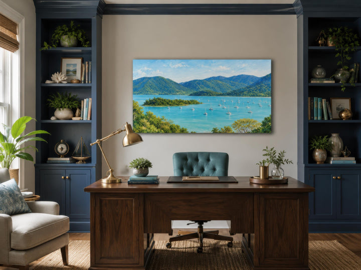 Panoramic tropical coastal canvas art featuring a turquoise bay and lush green islands over a desk.