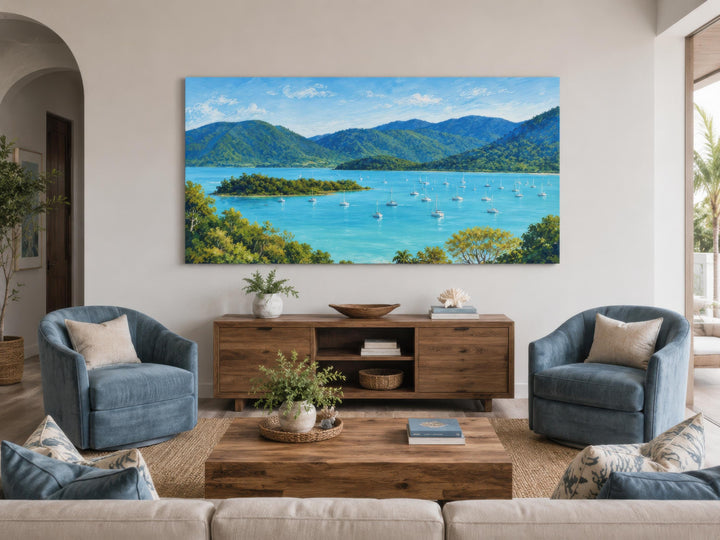 Panoramic tropical coastal canvas print of a turquoise bay with sailboats above a wooden console.