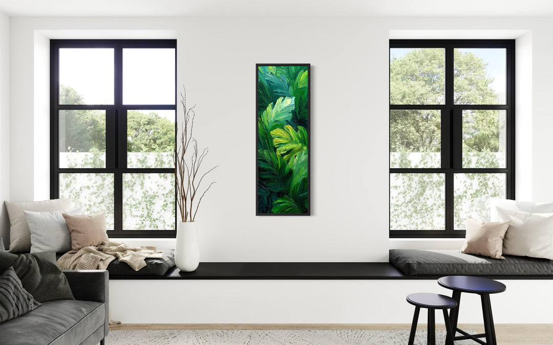 Vertical canvas print of a lush tropical jungle botanical painting on a white wall between windows.