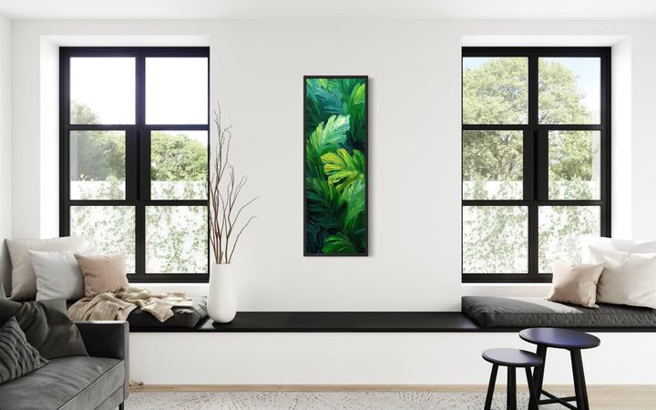 Vertical canvas print of a lush tropical jungle botanical painting on a white wall between windows.