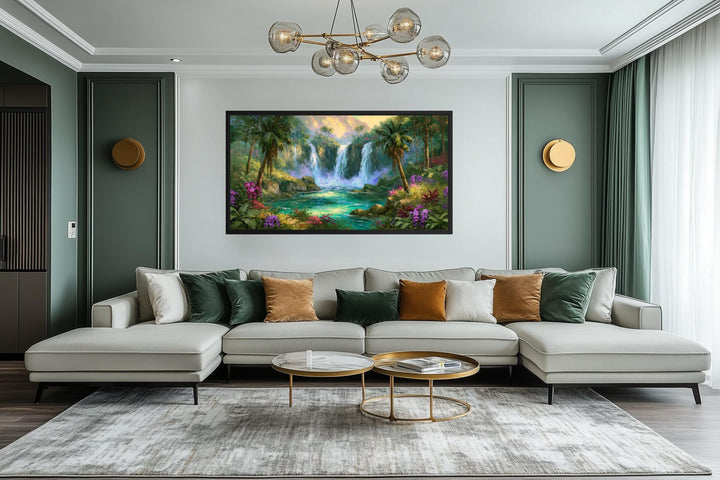 A wide horizontal canvas print of a lush tropical waterfall hangs above a modern sectional sofa.