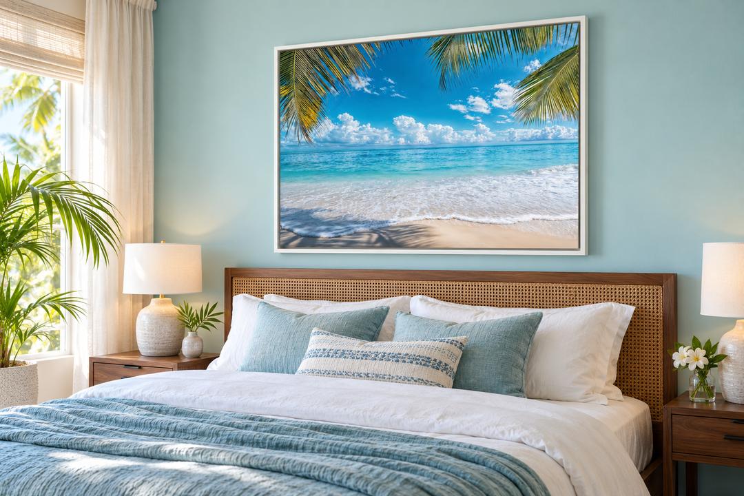 Tropical beach with palm tree framed canvas wall art hanging above a bed in a coastal bedroom.
