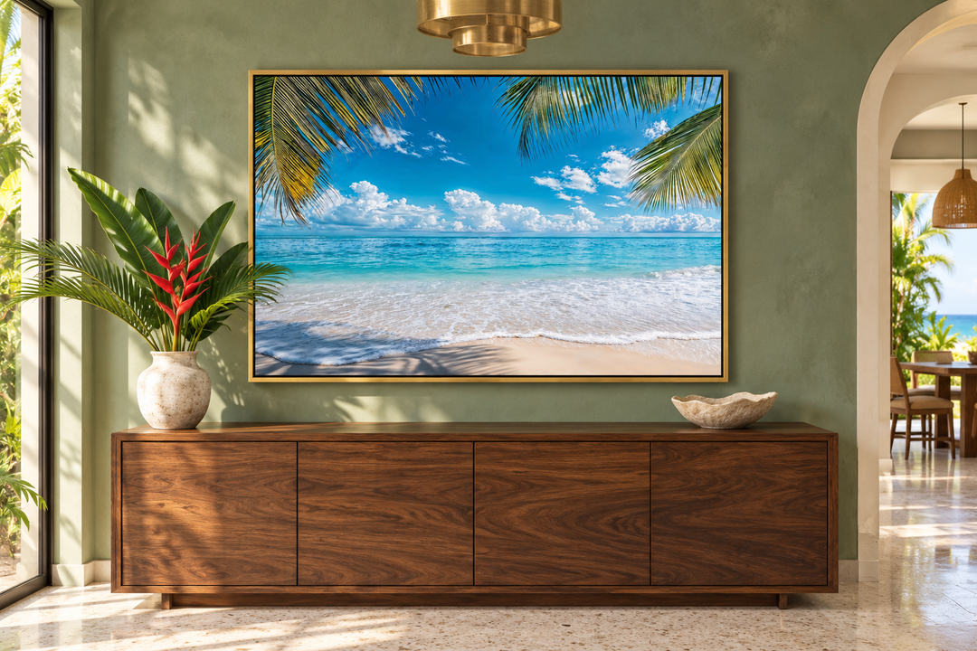 Tropical beach with palm tree framed canvas wall art above a wooden sideboard in a green room.