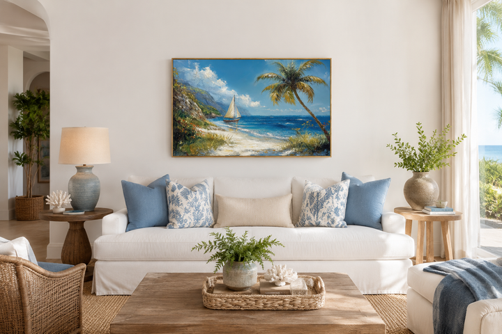 Tropical beach framed canvas wall art with a sailboat and palm tree above a white sofa.