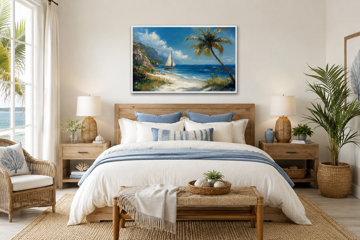 Coastal framed canvas wall art of a tropical beach with a sailboat and palm tree above a bed.