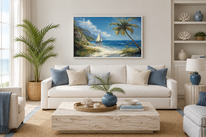 Tropical beach framed canvas wall art with a sailboat and palm tree above a white sofa.