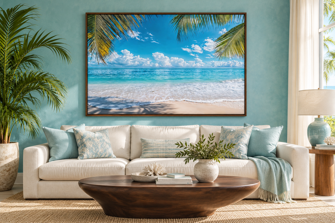 Tropical beach with palm tree framed canvas wall art hanging above a white sofa in a coastal room.