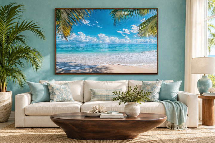 Tropical beach with palm tree framed canvas wall art hanging above a white sofa in a coastal room.