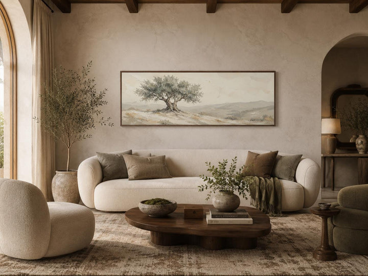 Long horizontal canvas print of a Tuscan olive tree in sage green and neutral tones above a sofa.