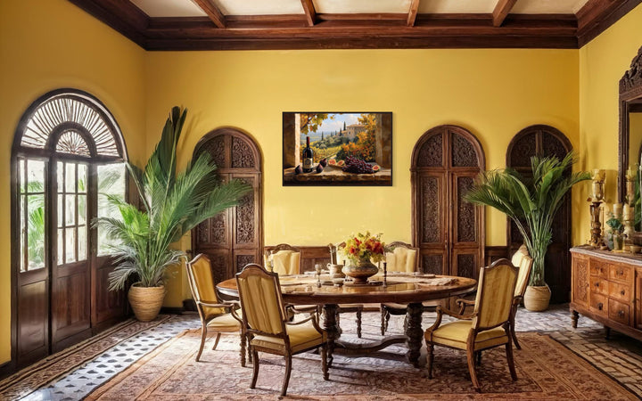 Tuscany vineyard window view wall art with wine bottle and grapes in a yellow dining room.