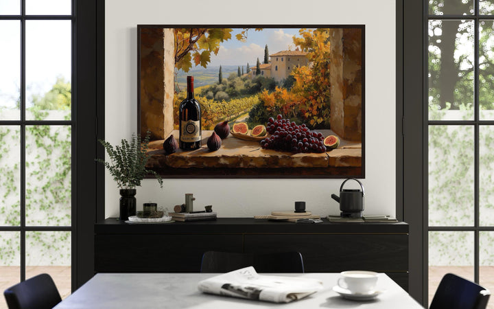 Tuscany vineyard window view wall art with wine bottle and grapes above a black dining room buffet.