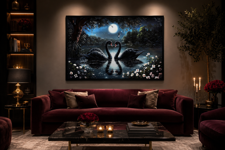 Framed canvas art of two black swans on a moonlit lake above a burgundy velvet sofa.
