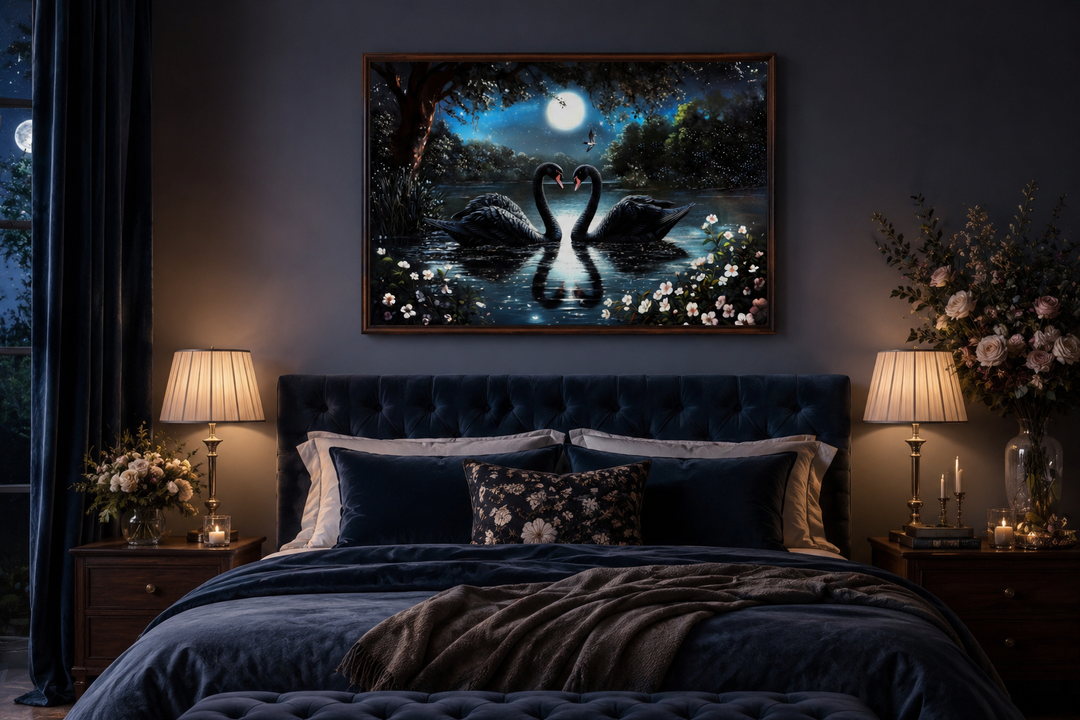 Framed canvas wall art of two black swans on a moonlit lake above a dark blue velvet bed.