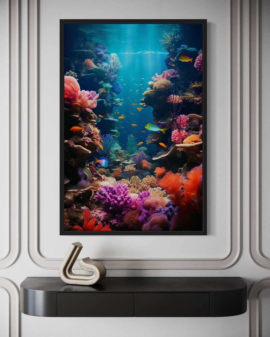 Underwater coral reef photograph with colorful fish in a black frame above a black console table.