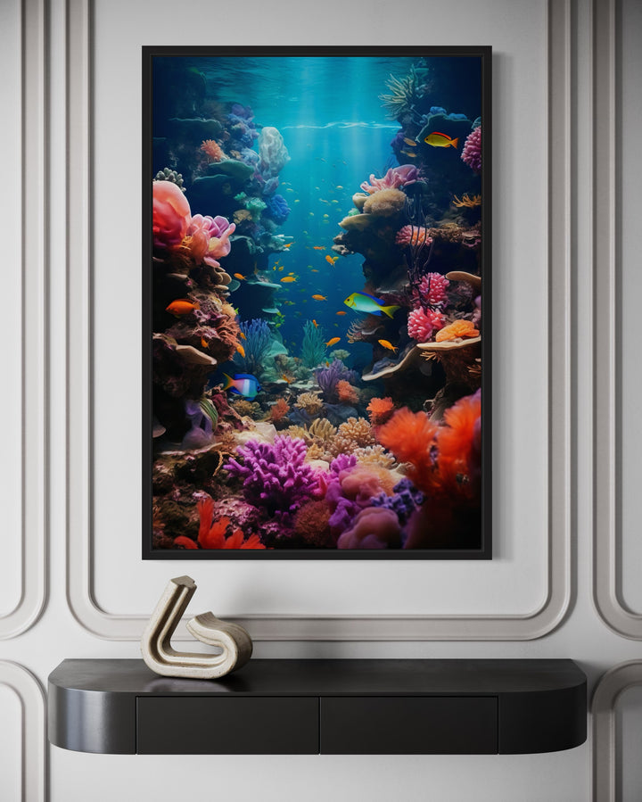 Underwater coral reef photograph with colorful fish in a black frame above a black console table.