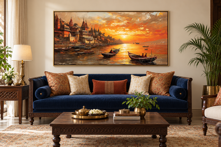 Framed Varanasi sunset canvas art above a blue velvet sofa in a traditional Indian living room.