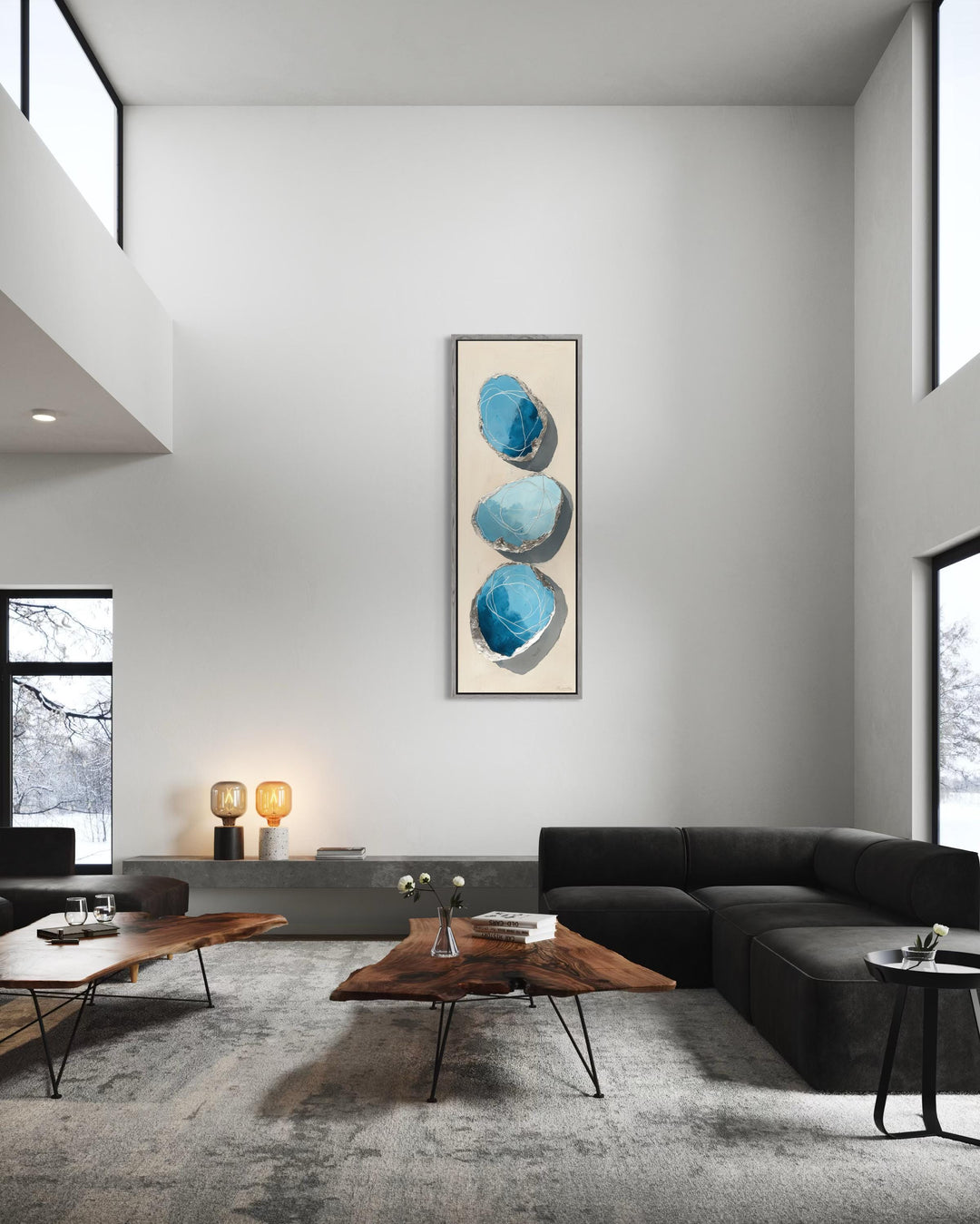 Vertical tall narrow canvas print featuring three abstract blue and silver stones on a neutral wall.