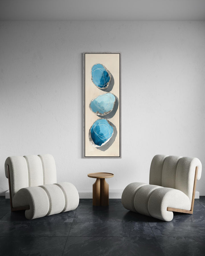 Vertical abstract canvas print featuring three blue and silver stones on a tall, narrow frame.