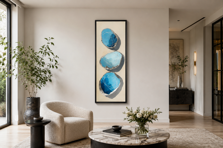 Vertical canvas print of three stacked abstract blue and silver stones on a neutral background.