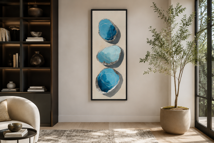 Vertical canvas print with three stacked abstract blue and silver stones on a neutral background.