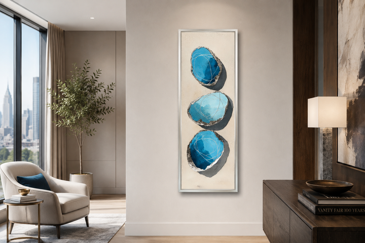Vertical canvas print with three stacked abstract blue and silver stones on a neutral background.