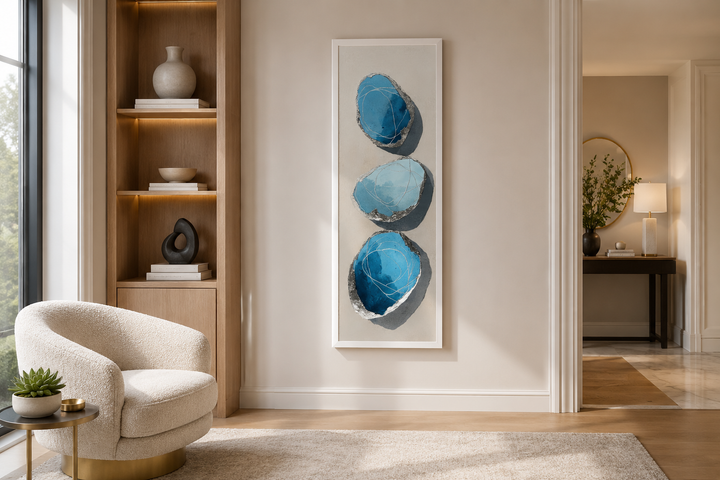 Vertical canvas print of three stacked abstract blue and silver stones on a neutral background.